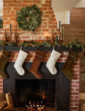 Two Bronson checkerboard pattern stockings hanging with other stockings on a mantel over a fireplace