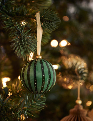 Joelle paper mache ornament hanging on a christmas tree branch