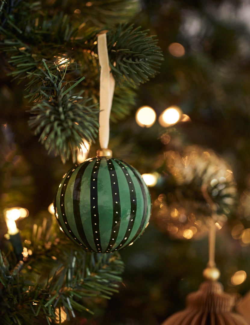 #style::green | Joelle paper mache ornament hanging on a christmas tree branch