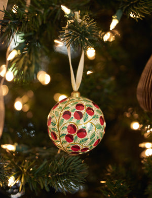 Joelle paper mache ornament hanging on a christmas tree branch