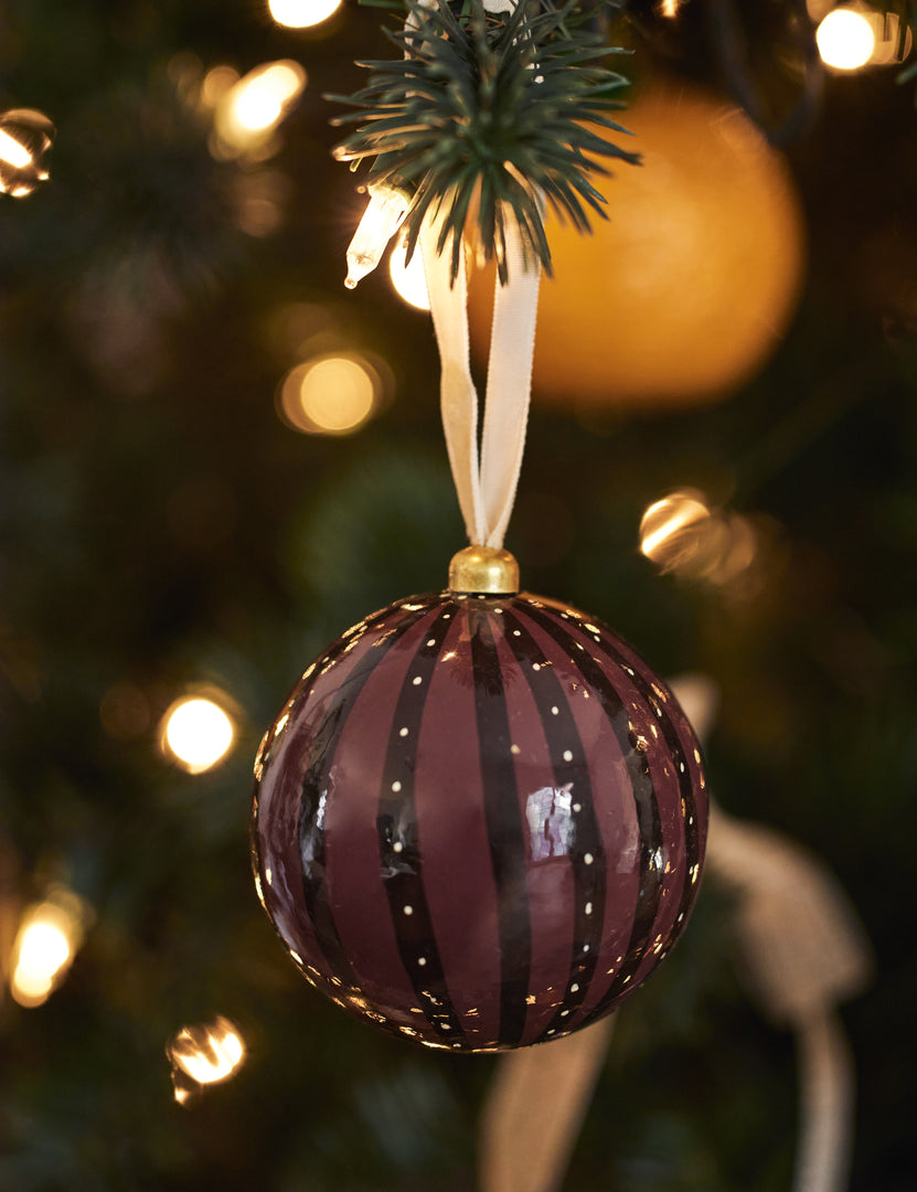 #style::sangria | Joelle paper mache ornament hanging on a christmas tree branch