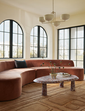 Living room featuring a curved sofa, marble coffee table and the Bosa abstract design hand-knotted wool rug.