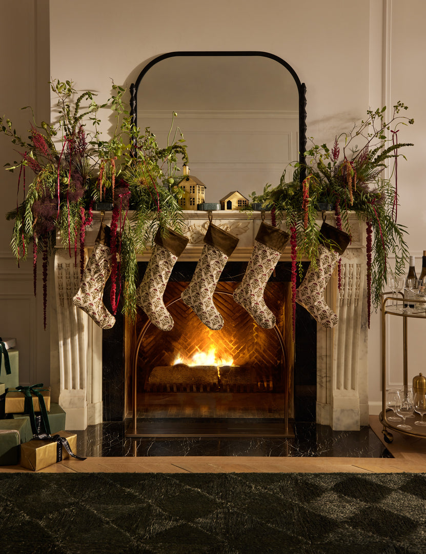 #color::red | Five Dove floral pattern stockings hanging on a mantel