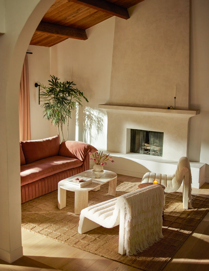 #color::travertine-and-marble | Living room featuring the Mahoe oval marble and travertine coffee table by Carly Cushnie.